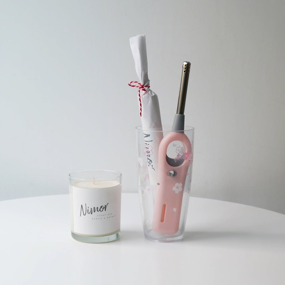 NIMOR Candle Lighter pink with gray neck beside Nimor candle, product lineup