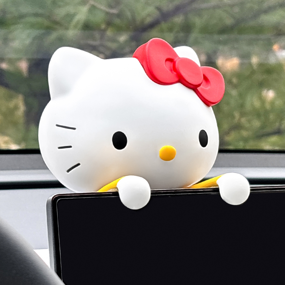 BELLE AMANT Hello Kitty Car Air Freshener hanging over navigation monitor, angled view