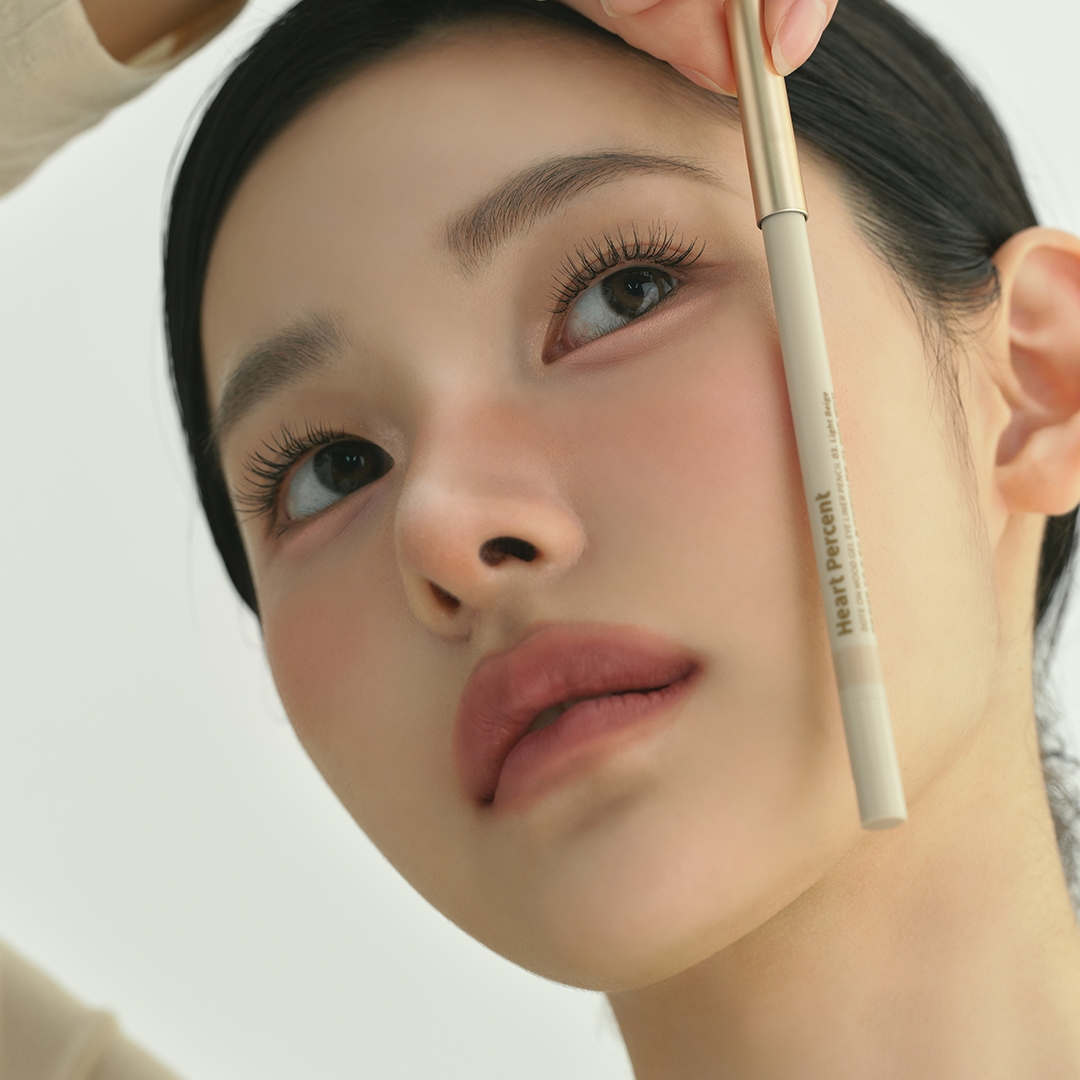 Heartpercent Dote on Mood Gel Eyeliner Pencil held up beside the face, label view