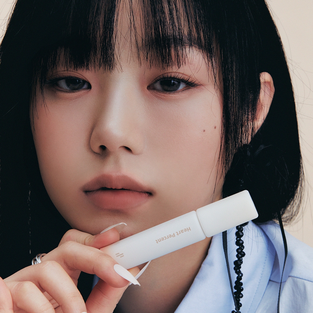 Heartpercent Dote on Mood All Cover Lip Base tube held on model, nude lips