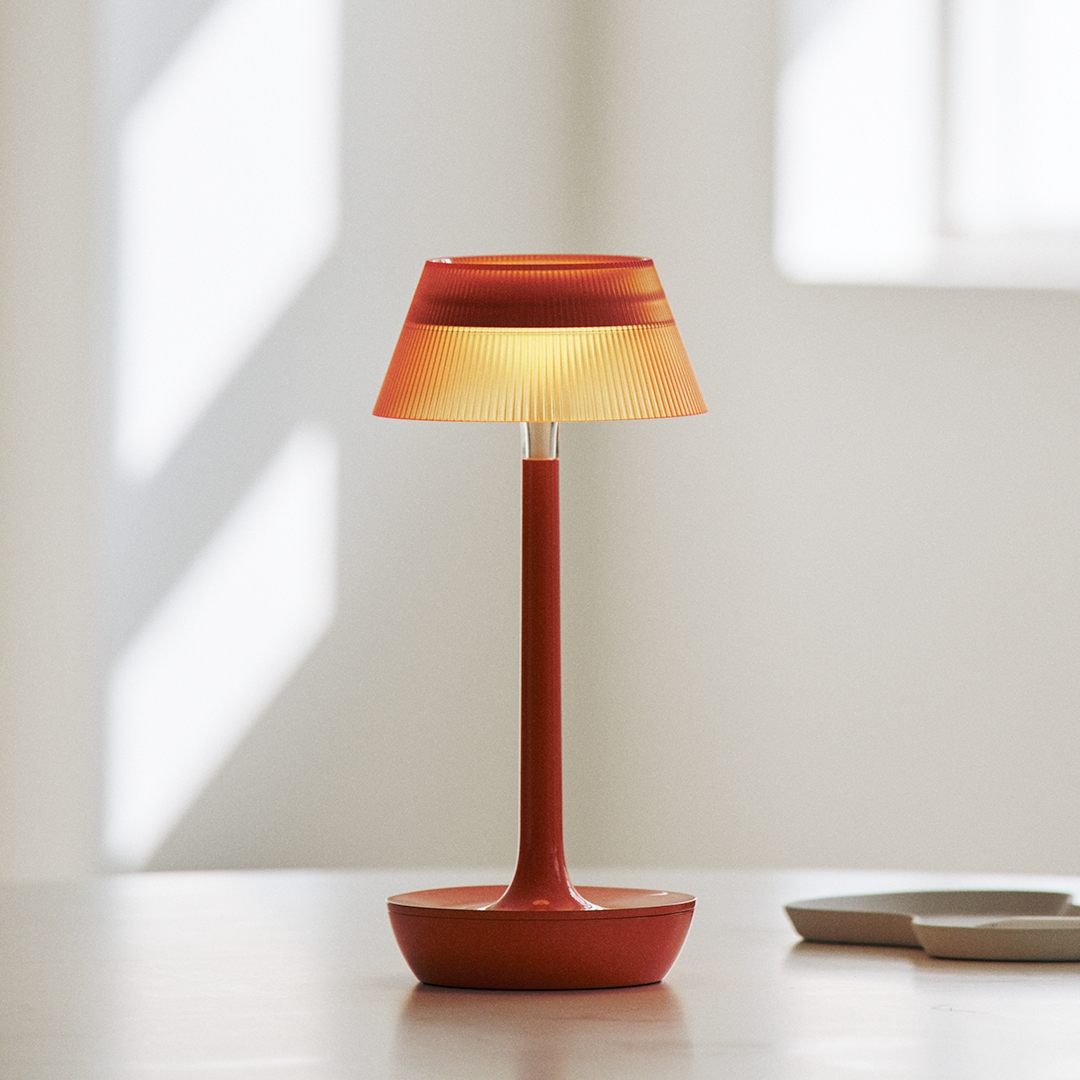 lumena SPACE ON PLUS portable table lamp Sun Orange with ribbed shade lit on table