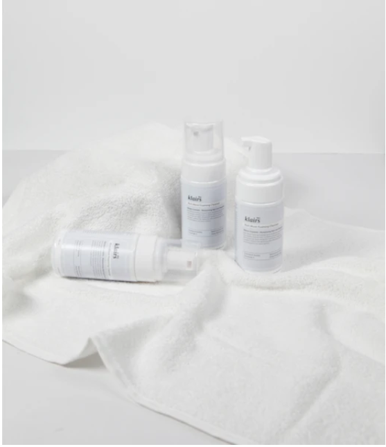 Klairs Rich Moist Foaming Cleanser 100ml pump bottles with foam, label close-up